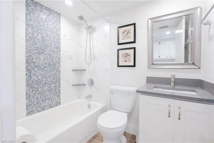 Bathroom with vanity, bathing tub / shower combination, and recessed lighting