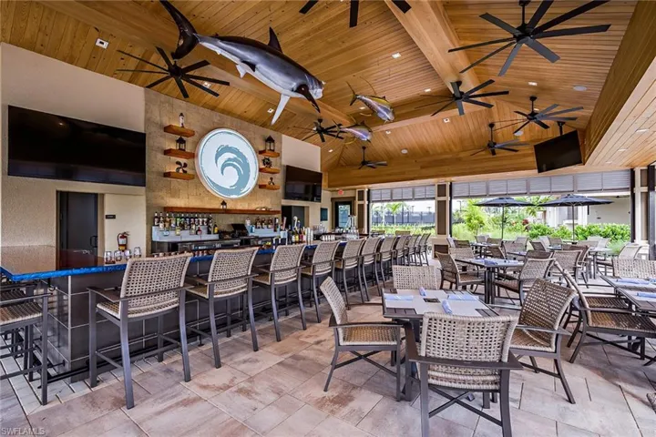 Dining room featuring beamed ceiling, high vaulted ceiling, bar, and wooden ceiling