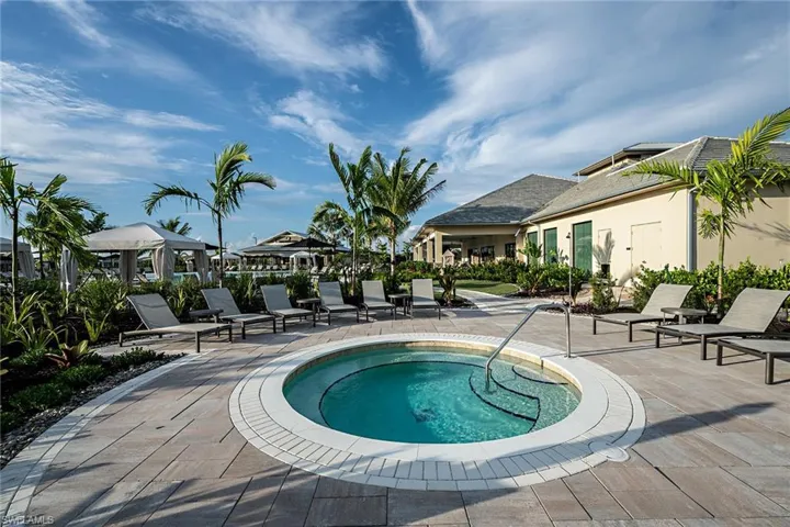 View of swimming pool featuring a community hot tub and a patio area