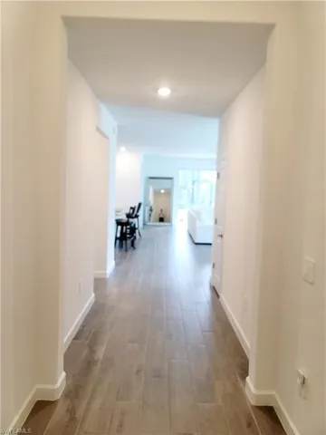 Hall featuring wood finished floors and recessed lighting