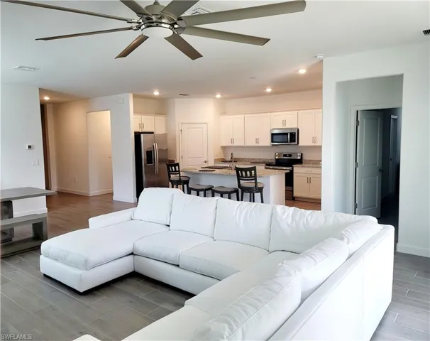 Living area featuring ceiling fan, wood tiled floors, and recessed lighting