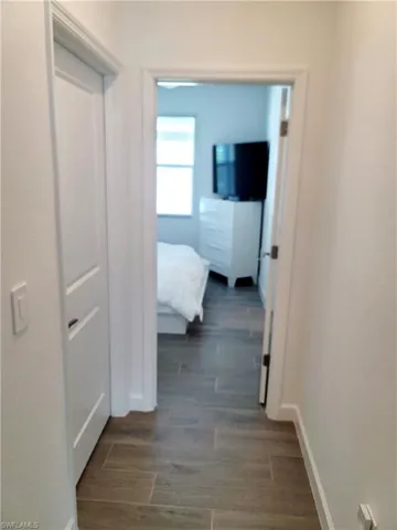 Corridor featuring dark wood-type flooring and baseboards