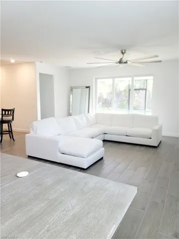 Living area featuring light wood-style floors and ceiling fan