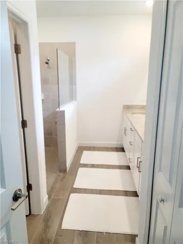 Full bathroom featuring vanity, walk in shower, and wood tiled floors