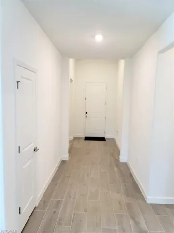 Hallway with wood finish floors and baseboards