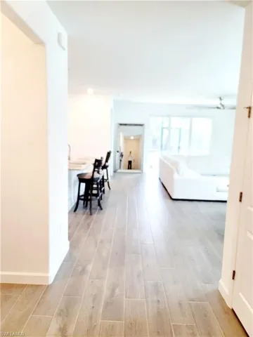 Corridor with light wood-style floors and baseboards