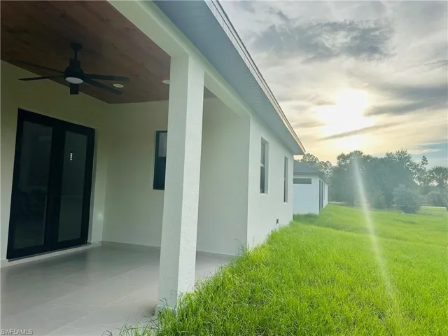 View of home's exterior with a ceiling fan, stucco siding, and a patio area