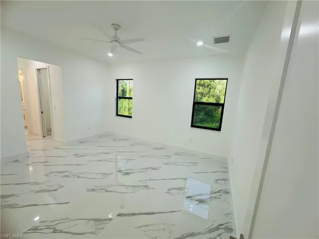 Unfurnished room featuring light marble finish floors, recessed lighting, and a ceiling fan