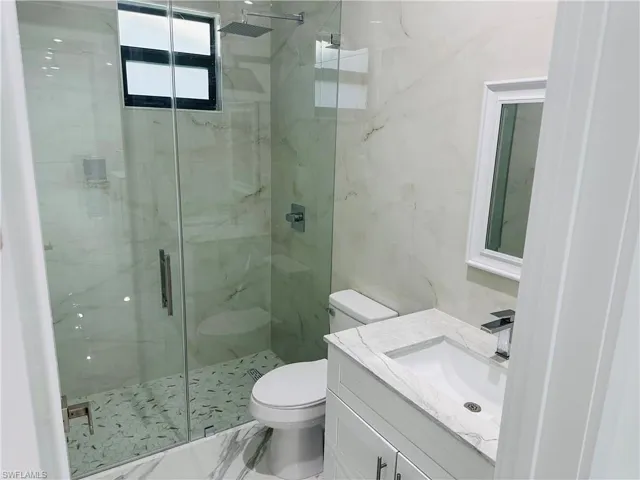 Full bathroom with a marble finish shower, vanity, and marble finish floors