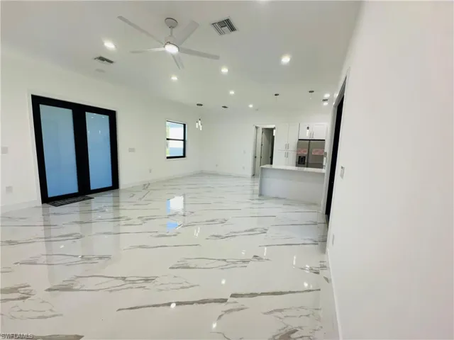 Empty room featuring light marble finish floors, recessed lighting, french doors, and ceiling fan