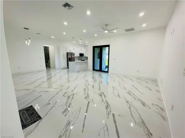 Unfurnished living room featuring recessed lighting, light marble finish floors, and ceiling fan
