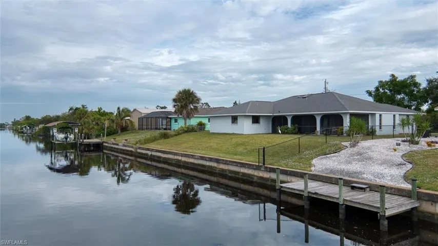 Dock area featuring a water view and a lawn