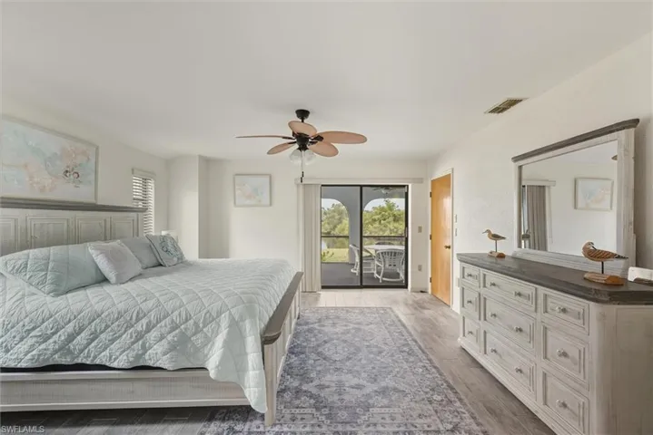 Primary Bedroom with multiple windows, ceiling fan, access to outside, and light wood finished floors