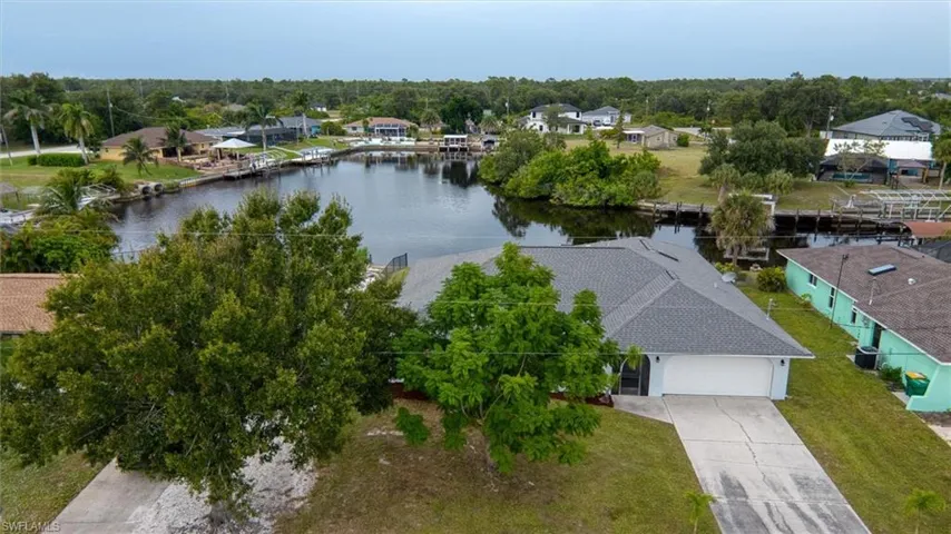 Aerial perspective of suburban area featuring a tree filled landscape and a nearby body of water