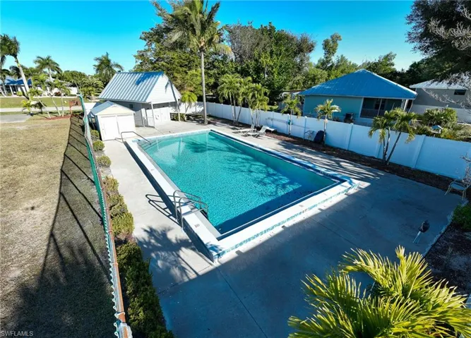 View of swimming pool featuring a fenced backyard, a patio, and an outbuilding