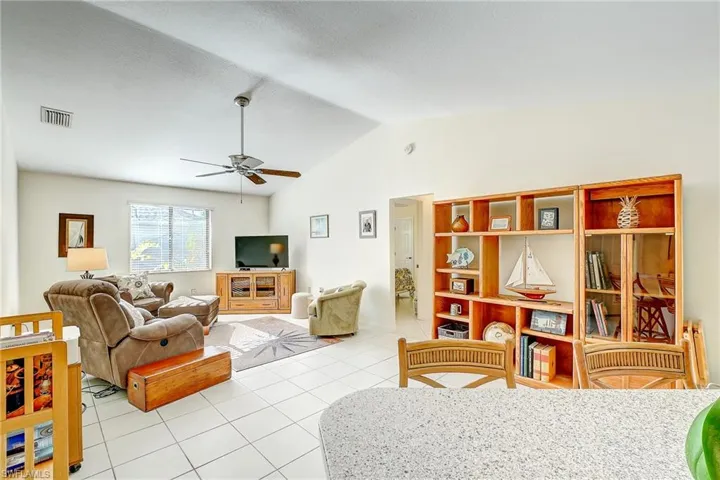 Living room featuring tile patterned floors and vaulted ceiling