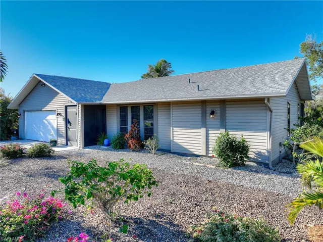 Single story home featuring a shingled roof and a garage