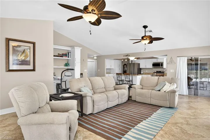 Living area with a ceiling fan and high vaulted ceiling