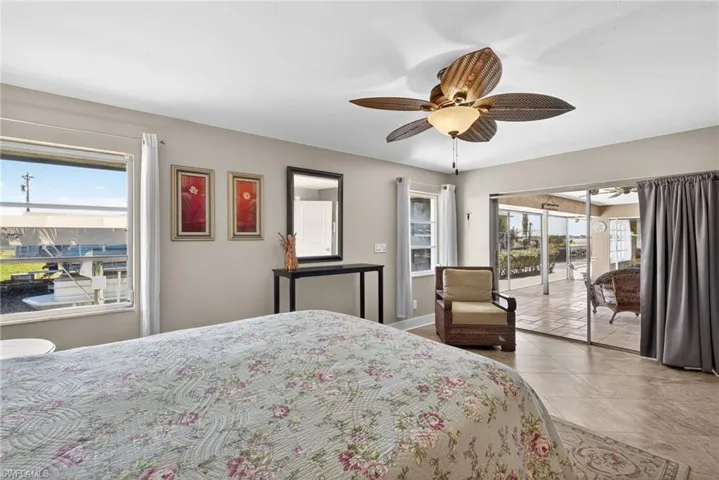 Tiled bedroom with access to outside and a ceiling fan