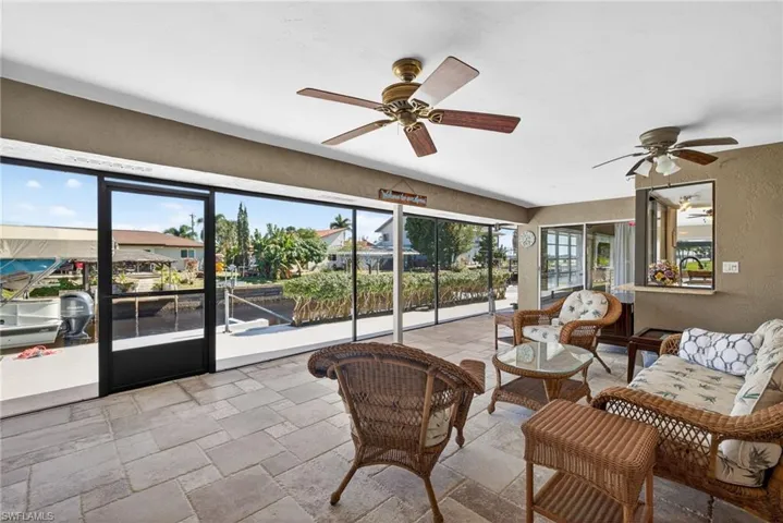 Sunroom / solarium featuring a textured wall and stone tile flooring