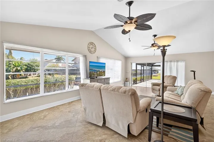 Living room featuring vaulted ceiling, healthy amount of natural light, and a ceiling fan