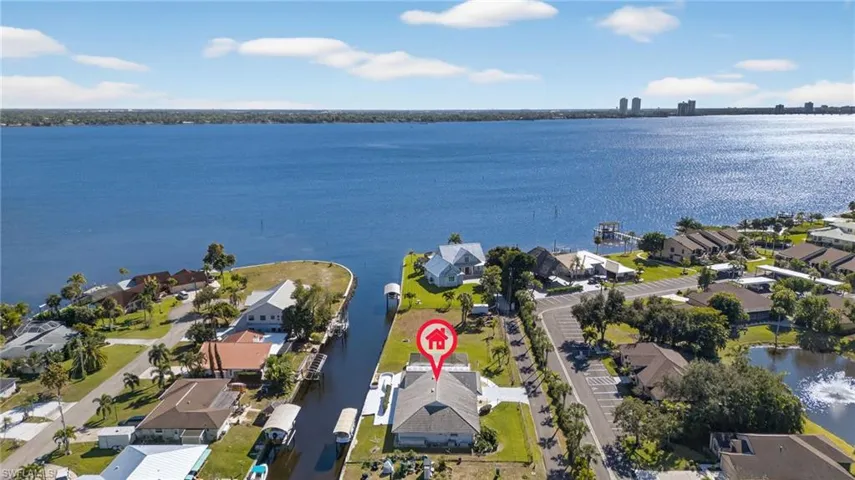 Aerial view of property's location featuring a large body of water and nearby suburban area