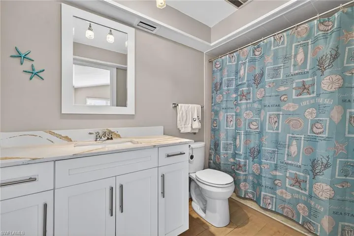 Full bath featuring curtained shower and vanity