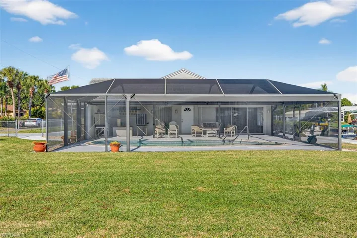 Rear view of house featuring glass enclosure and a sunroom