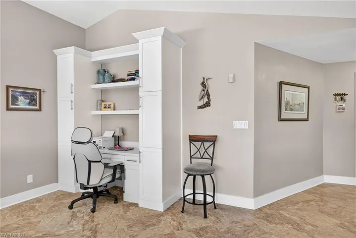 Home office with baseboards and vaulted ceiling