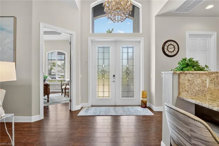 Entrance foyer with plenty of natural light, wood style floors, a chandelier, and French doors