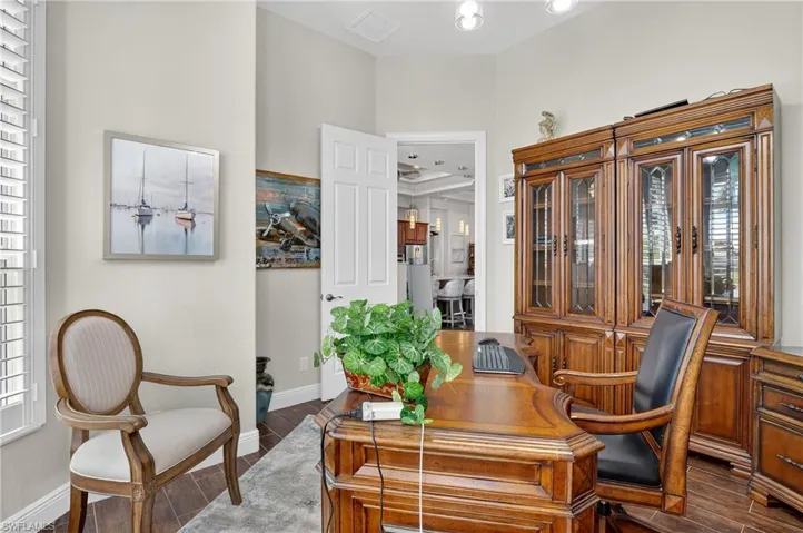 Home office with dark wood-style tile flooring and baseboards