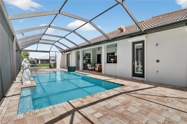 Outdoor pool featuring a ceiling fan, a lanai, and statues