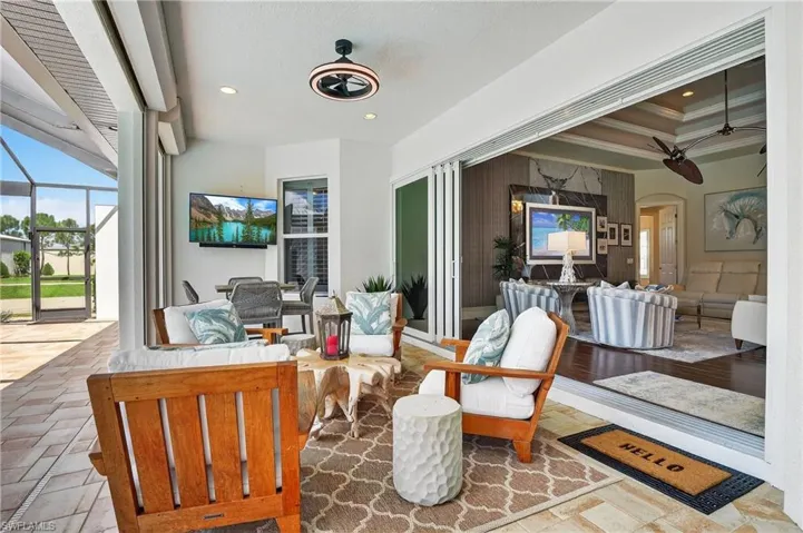 View of patio with an outdoor living space, new furniture, glass enclosure, and a ceiling fan
