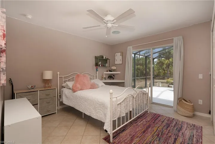 Bedroom with ceiling fan, baseboards, access to outside, and light tile patterned floors