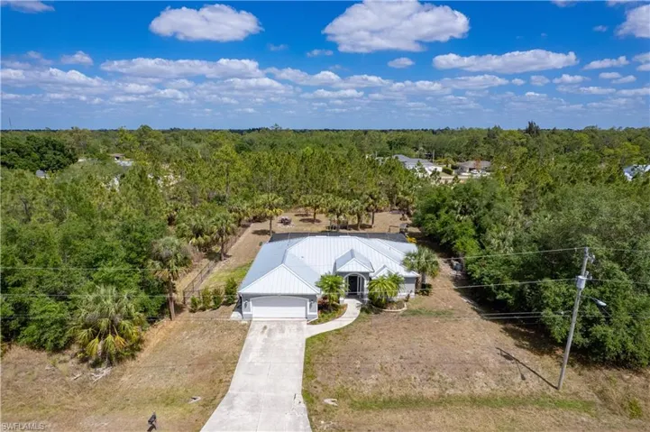 Birds eye view of property featuring a forest view
