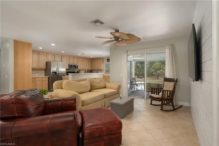 Living room featuring recessed lighting, visible vents, light tile patterned floors, baseboards, and ceiling fan