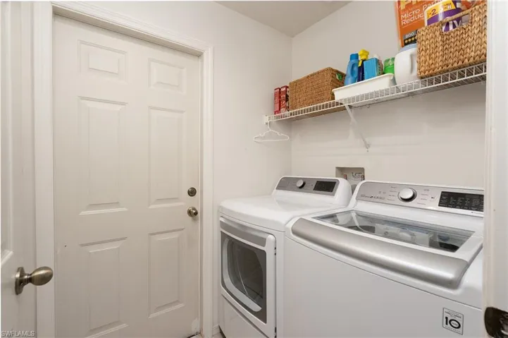 Washroom featuring washer and clothes dryer and laundry area