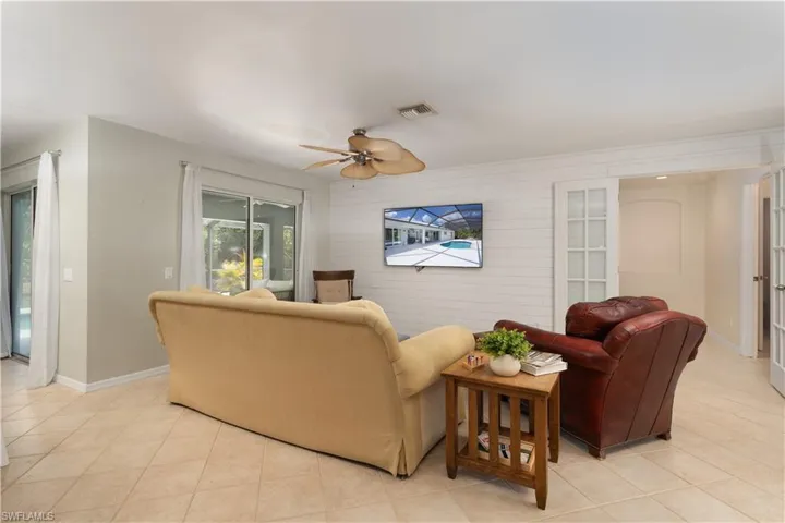 Living area with baseboards, a ceiling fan, visible vents, and light tile patterned floors