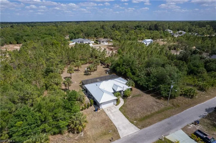 Birds eye view of property with a wooded view