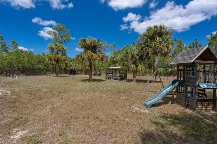 View of yard with fence and a playground