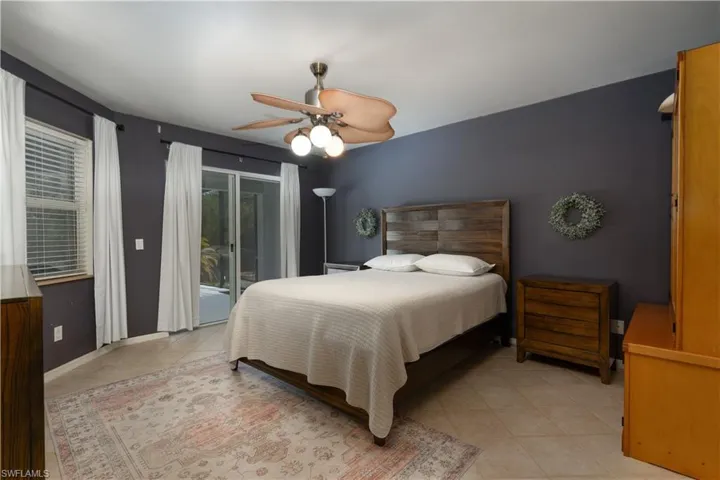 Bedroom with access to exterior, a ceiling fan, baseboards, and light tile patterned floors