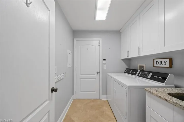 Laundry area featuring cabinet space and washing machine and dryer