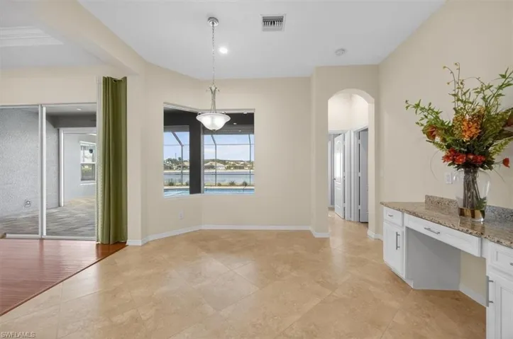 Unfurnished dining area with arched walkways and a water view