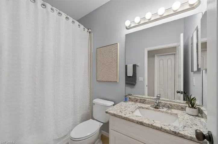 Bathroom with a shower with shower curtain and vanity