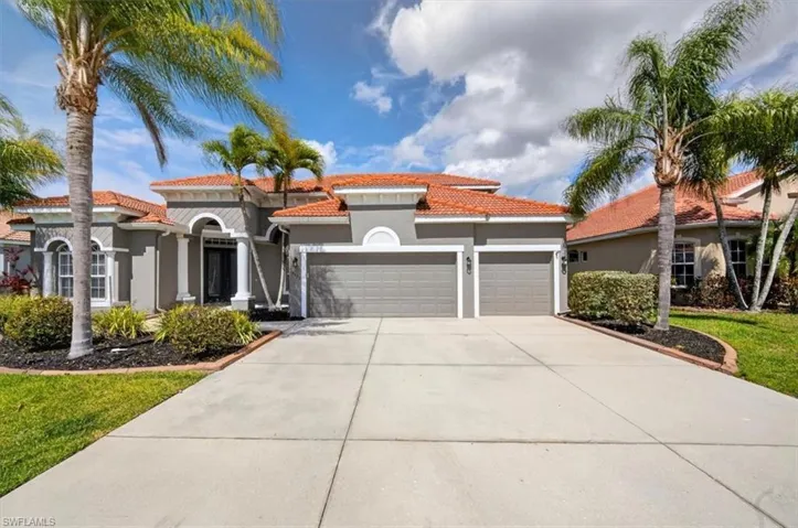 Mediterranean / spanish-style house featuring a garage, stucco siding, a tile roof, driveway, and a front lawn