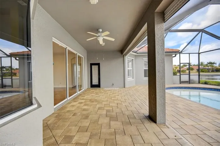 Swimming pool with glass enclosure, a sunroom, and a patio area