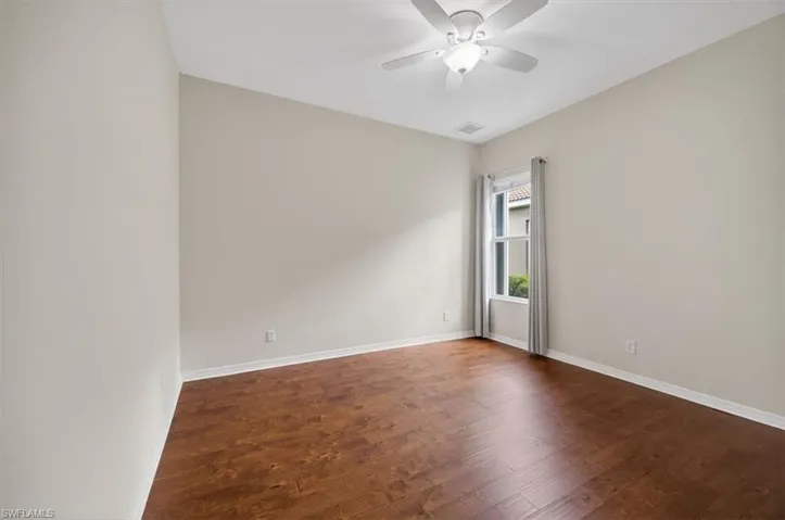 Spare room with dark wood-style floors and ceiling fan