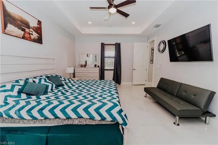 Bedroom featuring a raised ceiling and ceiling fan