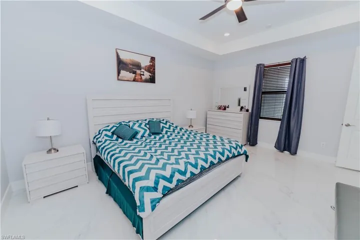 Bedroom with a tray ceiling and ceiling fan