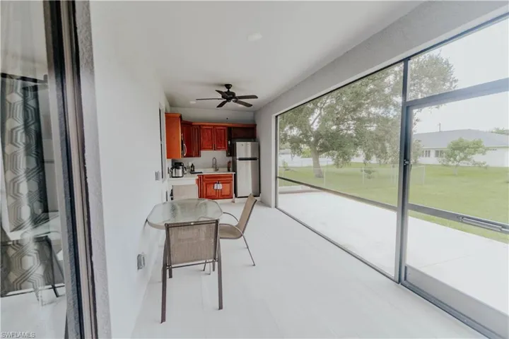 screened in Lanai with sink and ceiling fan and outdoors kitchen